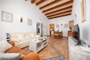 a living room with a couch and a tv at Villa Miguel Dos in Cala en Bosc