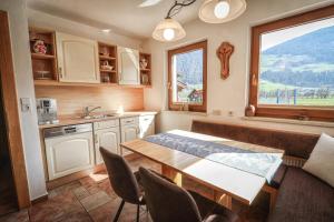 a kitchen with a table and chairs and a window at Gartenapartment Malea in Schlitters +40 photos