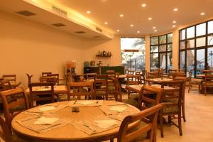 a restaurant with wooden tables and chairs and windows at Turquoise Beach Hotel in Sharm El Sheikh