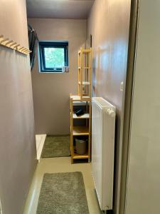 a small room with a shelf next to a refrigerator at Nykmark - Eco House - Room Selva in Bøstad +38 photos