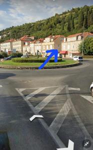 a blue arrow on a street with a city at Apartment Mia in Dubrovnik