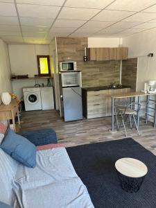 a living room with a couch and a kitchen at Les Cigales in La Crau