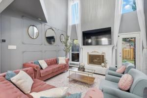 a living room with pink couches and a fireplace at French-Style 5-BD w/ Pool, Playground, Cinema in Lewisville