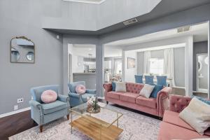 a living room with a pink couch and blue chairs at French-Style 5-BD w/ Pool, Playground, Cinema in Lewisville +51 photos