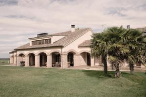 una gran casa blanca con una palmera en el patio en La Casona del Tormes, en Almenara de Tormes