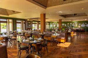 a restaurant with tables and chairs and a bar at Hotel Vila Inglesa in Campos do Jordão