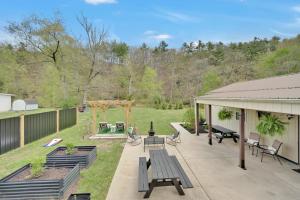 a backyard with a picnic table and benches at Cozy Home Retreat by the River in Cressona