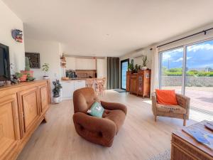a living room with two chairs and a kitchen at La Villetta Penmarch in Penmarch