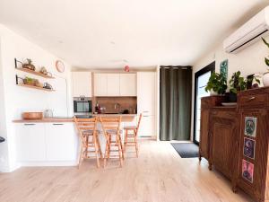 a kitchen with white cabinets and a table and chairs at La Villetta Penmarch in Penmarch +10 photos