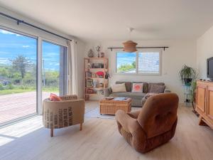 a living room with a couch and chairs and a window at La Villetta Penmarch in Penmarch