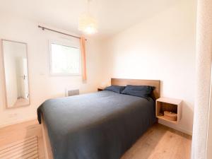 a bedroom with a bed and a window at La Villetta Penmarch in Penmarch