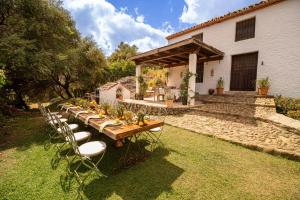 a long wooden table and chairs in a yard at Finca Santa Teresa, Casa Grande in Estepona