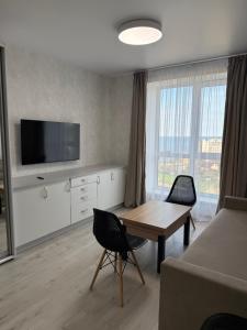 a living room with a table and a tv at Студия с Видом на Море, 10-2 in Chornomorsk