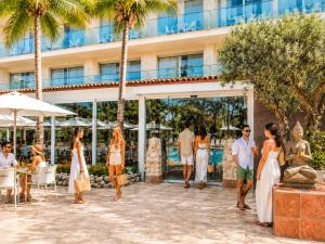 a group of people standing outside of a hotel at Hotel la Palmera & Spa in Lloret de Mar