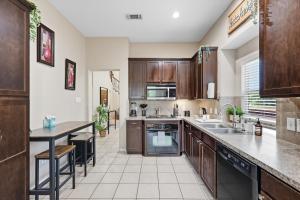 a large kitchen with wooden cabinets and a table at Spacious 5-BD 3-BA Forest View Getaway Sleeps 13 in Dallas