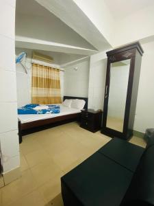a small room with a bed and a mirror at Hotel Al Fahad in Dhaka +22 photos