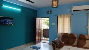 a living room with blue walls and a couch at Yardlin Hotel in Perunkalattu