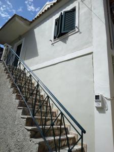 eine Treppe, die zu einem weißen Gebäude mit einem Fenster hinaufführt in der Unterkunft RIVER SIDE HOUSE in Potámion