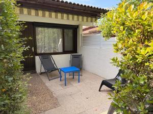 a blue table and two chairs on a patio at Le cottage landais in Lit-et-Mixe
