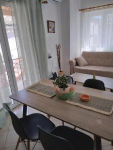 ein Wohnzimmer mit einem Holztisch und Stühlen in der Unterkunft RIVER SIDE HOUSE in Potámion
