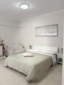 a white bedroom with a large bed and a couch at B&B Sibi in Chieti