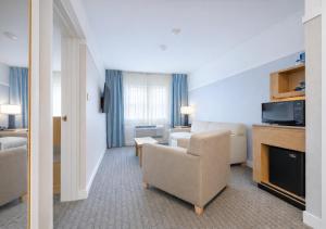 a hotel room with a couch and a chair at Two Trees Inn in Ledyard Center +24 photos