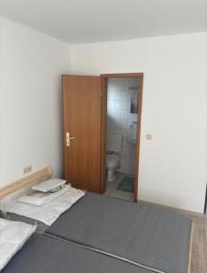 a room with a bed and a bathroom with a toilet at Monteurhome Monteurzimmer A7 A5 in Niederaula