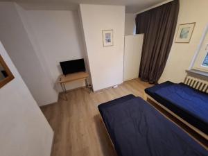 a bedroom with a bed and a desk with a television at Monteurhome Monteurzimmer A7 A5 in Niederaula