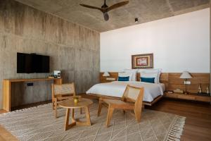 a bedroom with a bed and a table and a tv at The Coast Sri Lanka, Bentota in Bentota