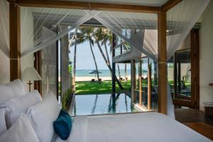 a bedroom with a bed and a view of the ocean at The Coast Sri Lanka, Bentota in Bentota