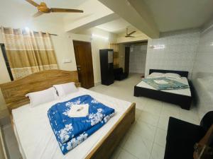 a bedroom with two beds and a ceiling fan at Hotel Al Fahad in Dhaka