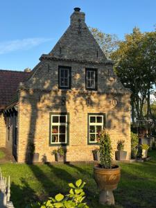 an old brick house with a planter in front of it at Ut ânker fan de Jong in Hollum