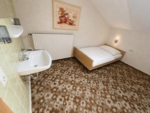 a small bathroom with a sink and a bed at GreenHell Stays Monteur - Nürburg in Nürburg