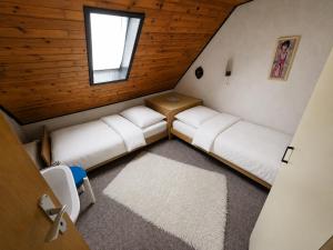 an attic room with two beds and a window at GreenHell Stays Monteur - Nürburg in Nürburg
