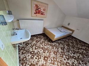 a small bathroom with a sink and a bed at GreenHell Stays Monteur - Nürburg in Nürburg