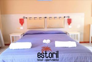 a bed with two white towels on top of it at Estoril Hotel - Apartments in Sal Rei