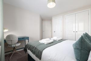 a bedroom with a bed with a desk and a chair at Sea Point - 2 bed apartment in Saltcoats