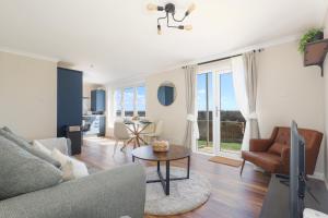 a living room with a couch and a table at Sea Point - 2 bed apartment in Saltcoats