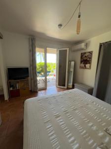 a bedroom with a bed and a view of a patio at O Ti Boneur in Sainte-Rose