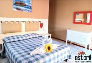 a bedroom with a bed with a sunflower on it at Estoril Hotel - Apartments in Sal Rei