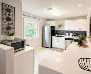 a kitchen with white cabinets and a stainless steel refrigerator at Backwater Bliss 3BD, 2BA, Grill, Pet Friendly 20PP in Osage Beach