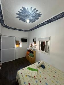 a bedroom with a bed with a flower painted on the ceiling at Casa Abdel in Larache