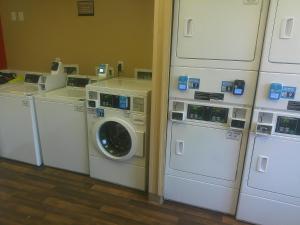 a laundry room with washing machines and a washer and dryer at HomeTowne Studios by Red Roof Chantilly in Chantilly