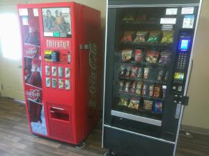 a coca cola vending machine next to a soda machine at HomeTowne Studios by Red Roof Chantilly in Chantilly +6 photos