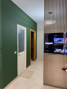 a living room with green walls and a flat screen tv at Seaside Family Escape in Golem