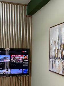 a flat screen tv hanging on a wall with a picture at Seaside Family Escape in Golem