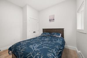 a bedroom with a bed with a blue comforter at Private Farm Escape with Modern Comforts in Abbotsford