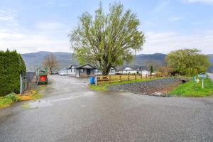 an empty road with a fence and a house at Private Farm Escape with Modern Comforts in Abbotsford +8 photos
