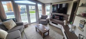 a living room with a couch and a tv at LJ Holiday Let in Middleton