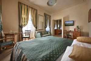 a bedroom with a bed and a desk and chairs at U Schnellu in Prague